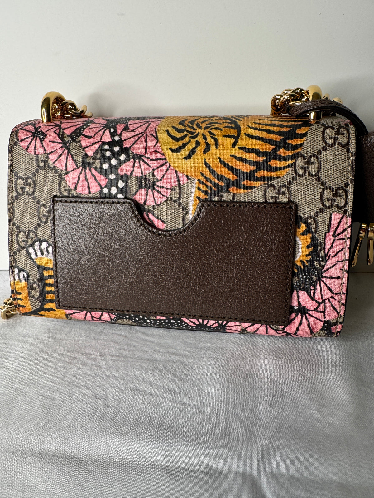 Back of Gucci GG tiger and floral print bag showing dark brown slip pocket