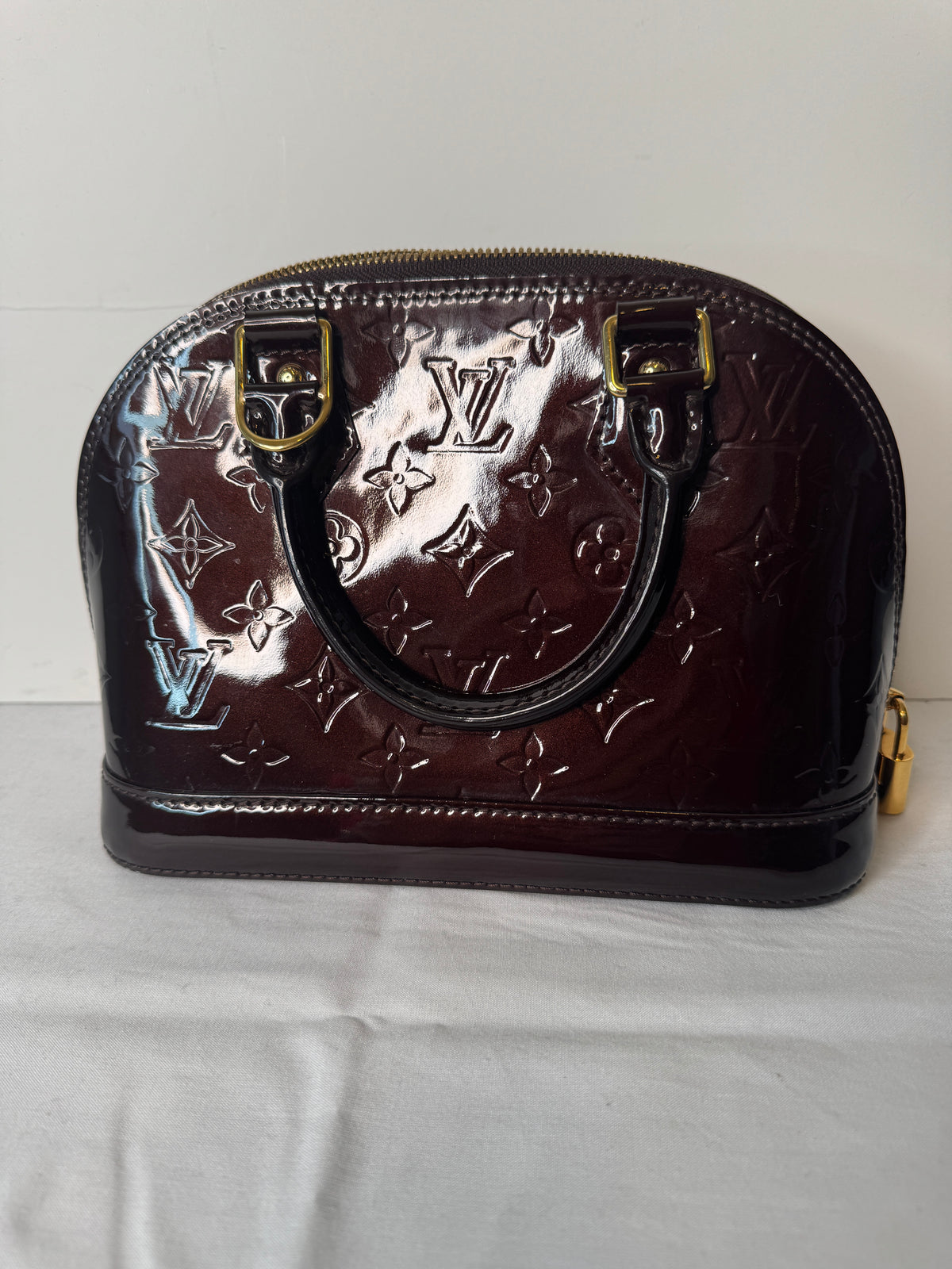 Opposite exterior view of burgundy Louis Vuitton monogram top handle bag