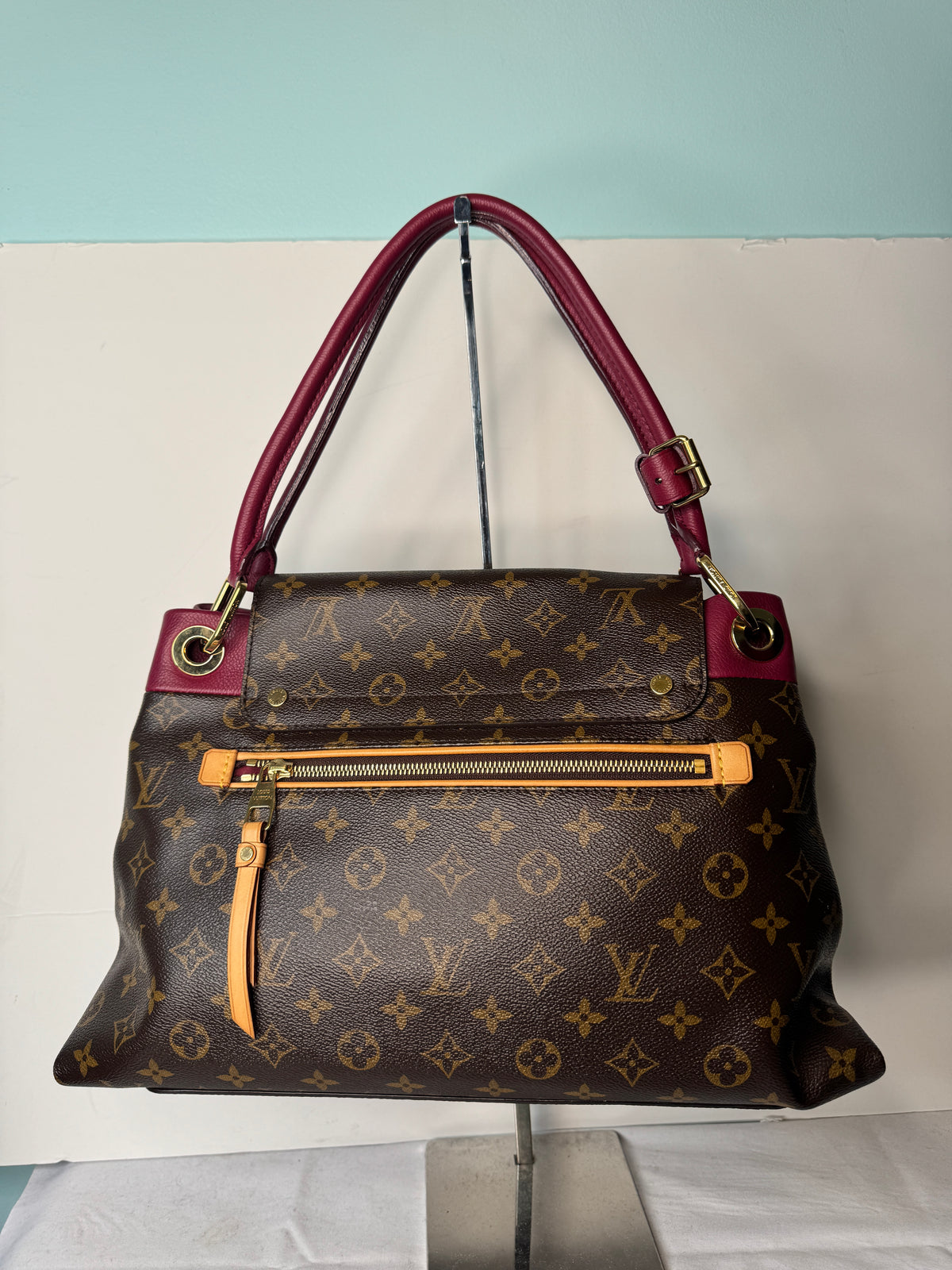 Rear view of Louis Vuitton monogram shoulder bag with exterior zip pocket and burgundy strap
