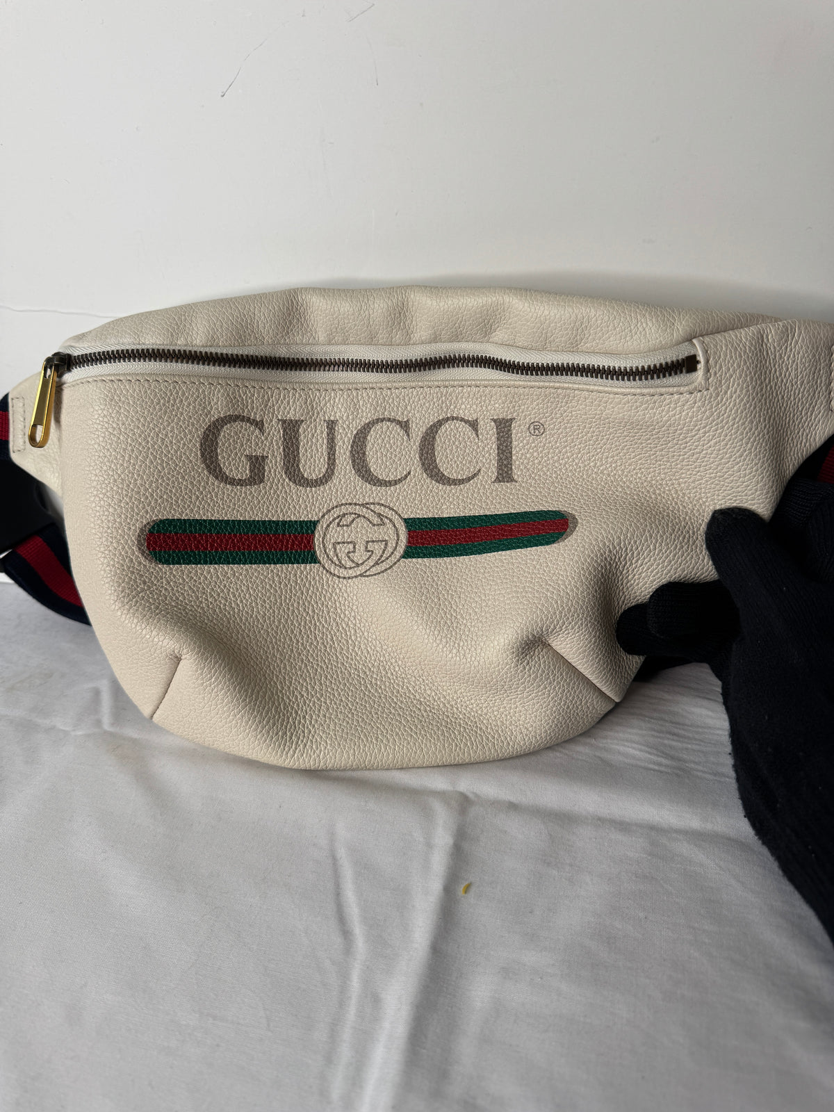 Cream Gucci logo belt bag with green-and-red stripe and zip closure