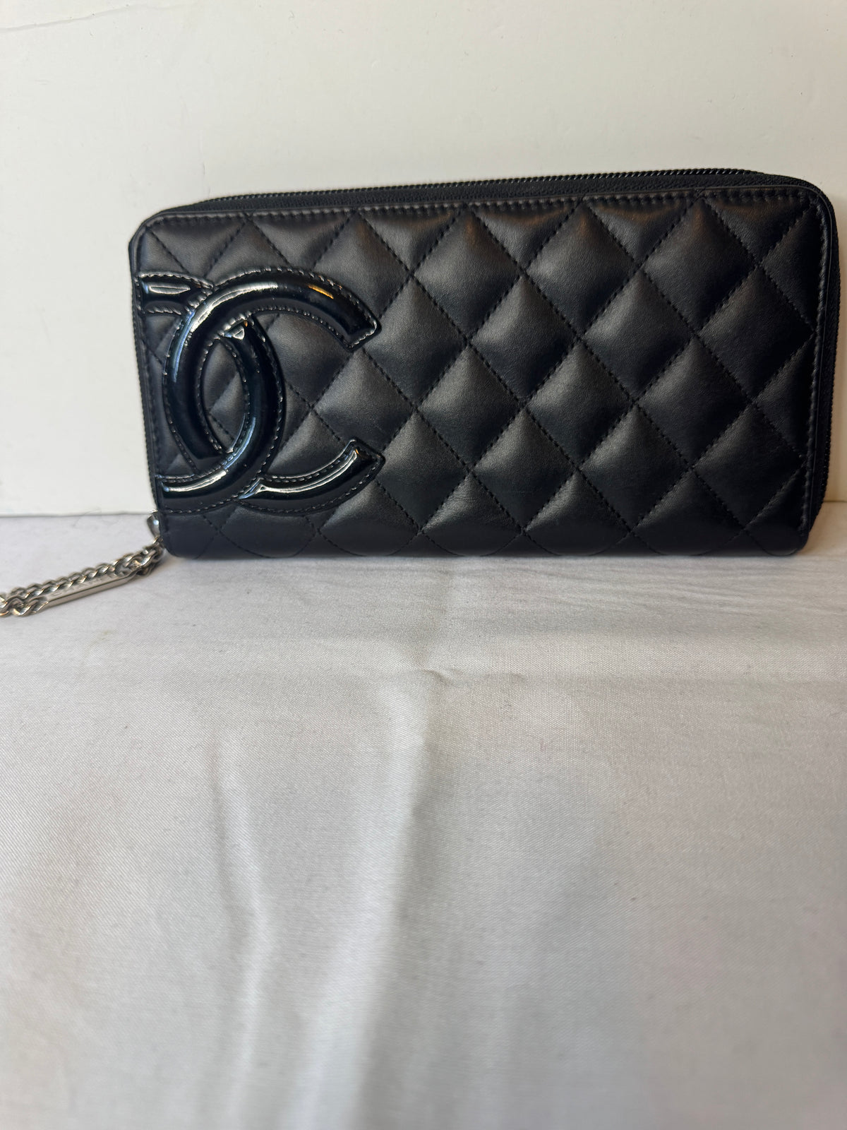 Black diamond-quilted wallet with oversized tonal CC detail and zip-around closure