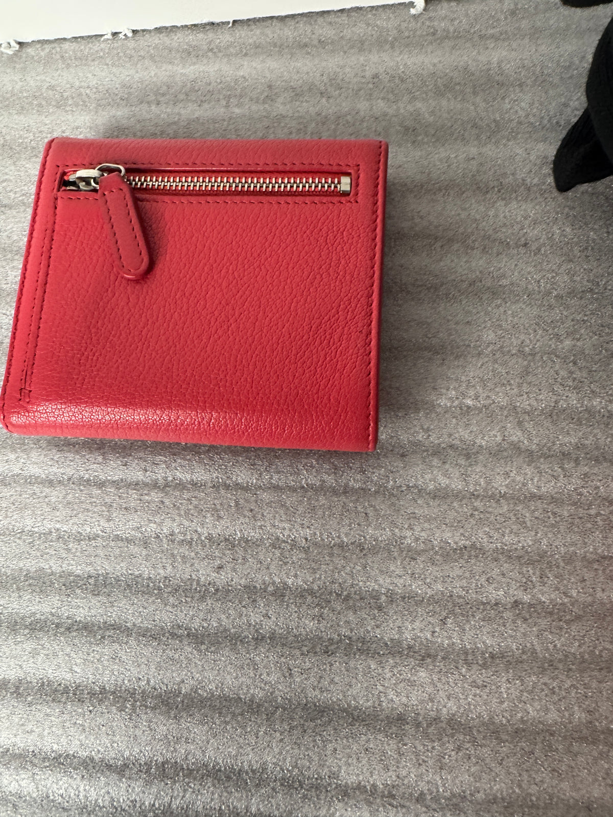 Red Chanel compact wallet front with silver-tone CC emblem