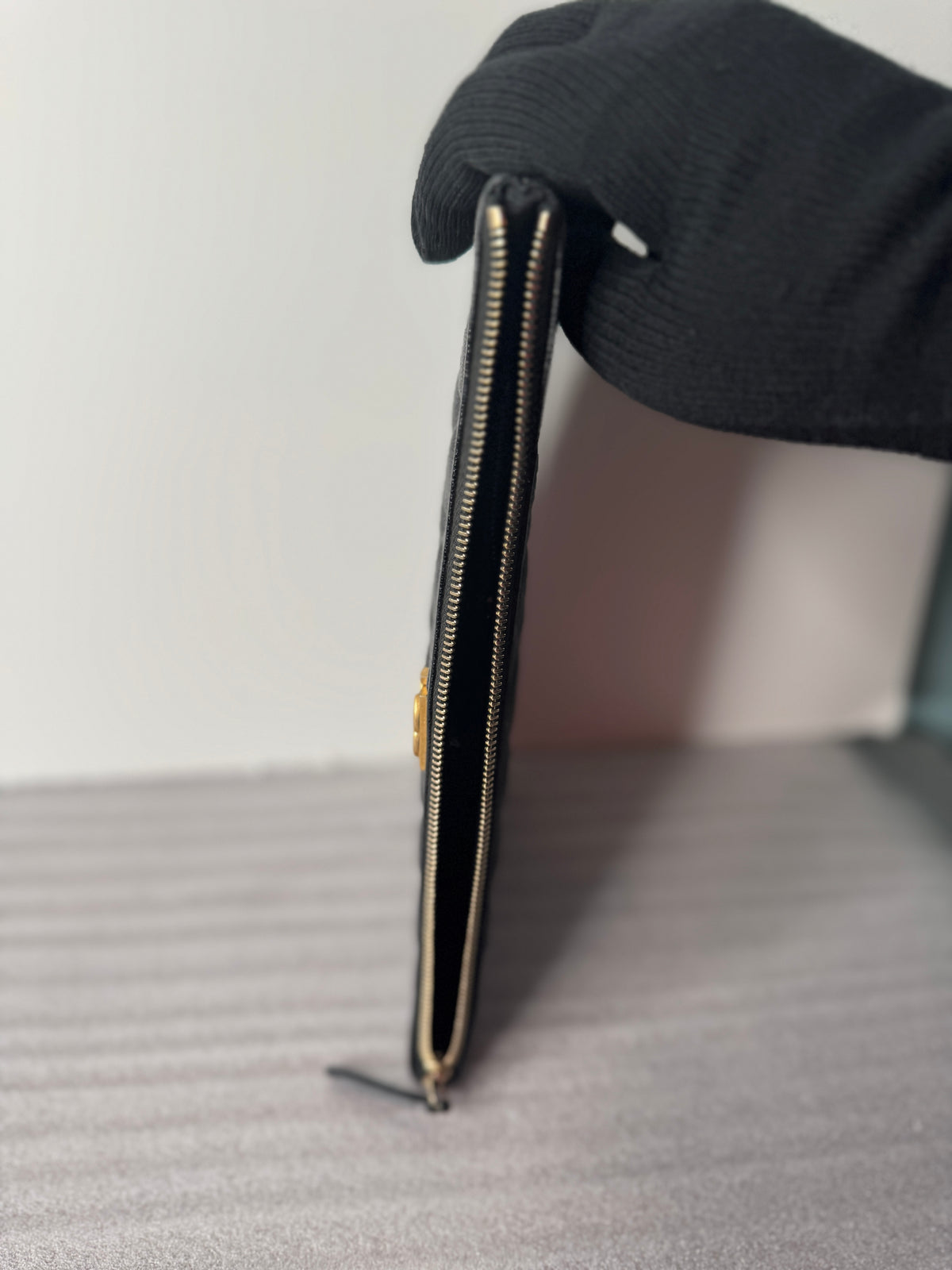 Open clutch showing black lining and zip pocket