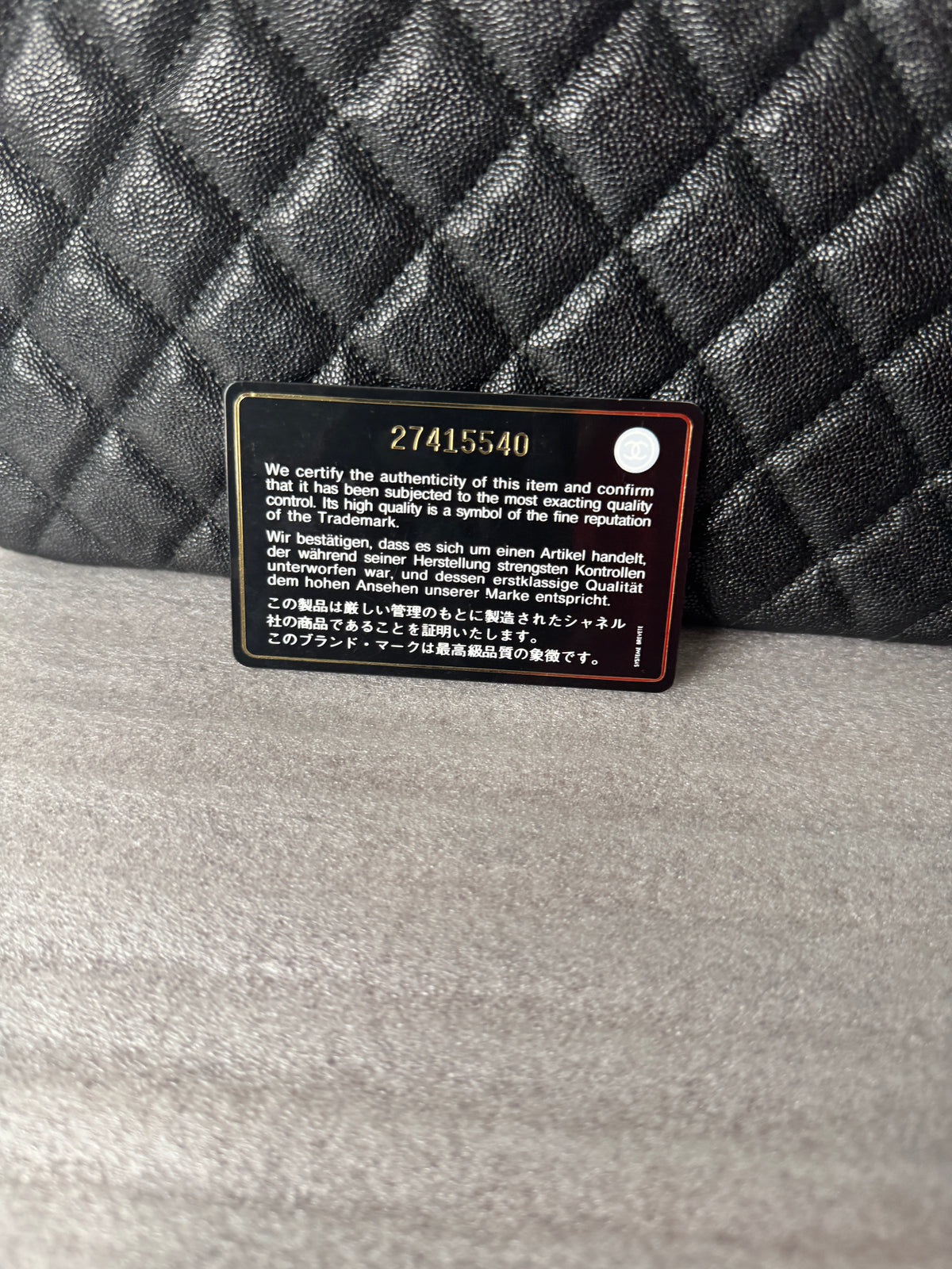 Reverse side of Chanel card photographed alongside clutch